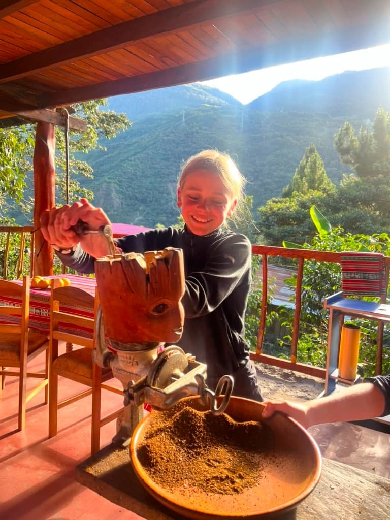 Guest grinding coffee on the terrace overlooking the mountains