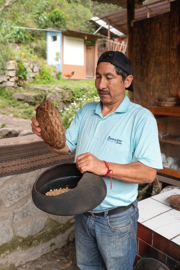Opening a clay pot of parchment coffee beans