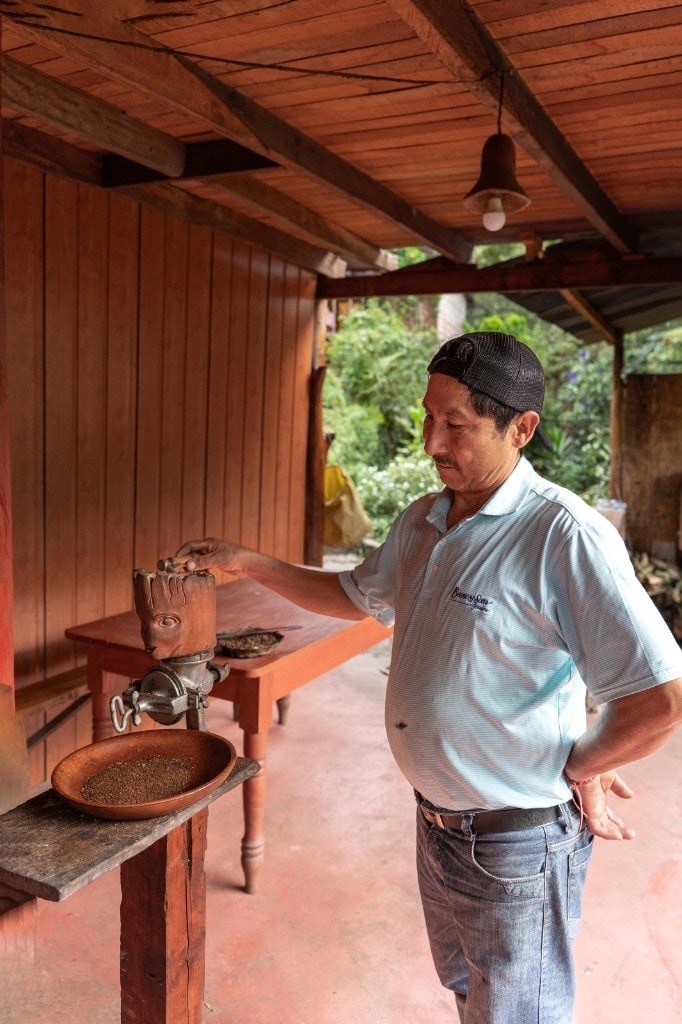 Grinding coffee on a traditional wooden hand mill