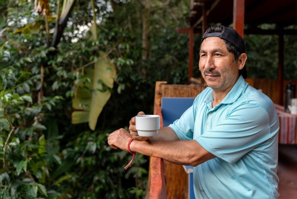 Host with a cup of coffee on the mountain terrace